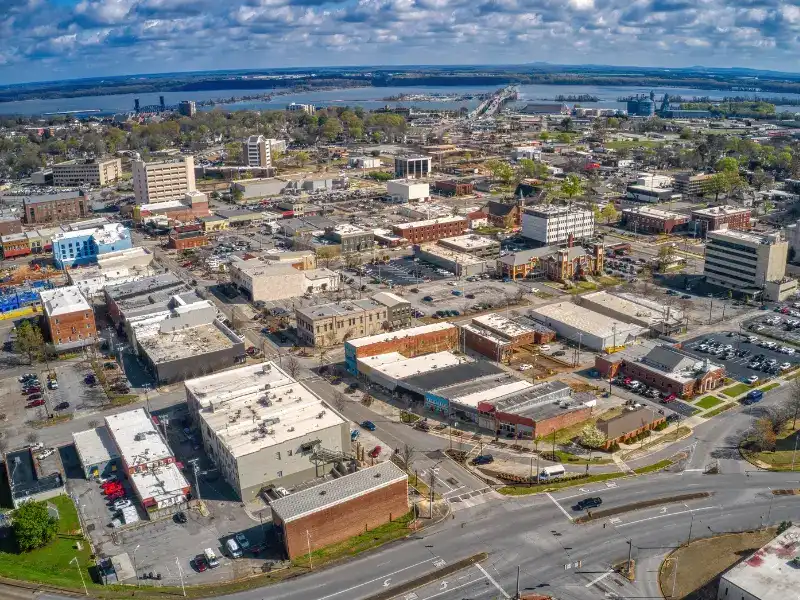 Aerial view of a small city with buildings, roads, and a river in the background under a partly cloudy sky. water damage restoration in Decatur AL