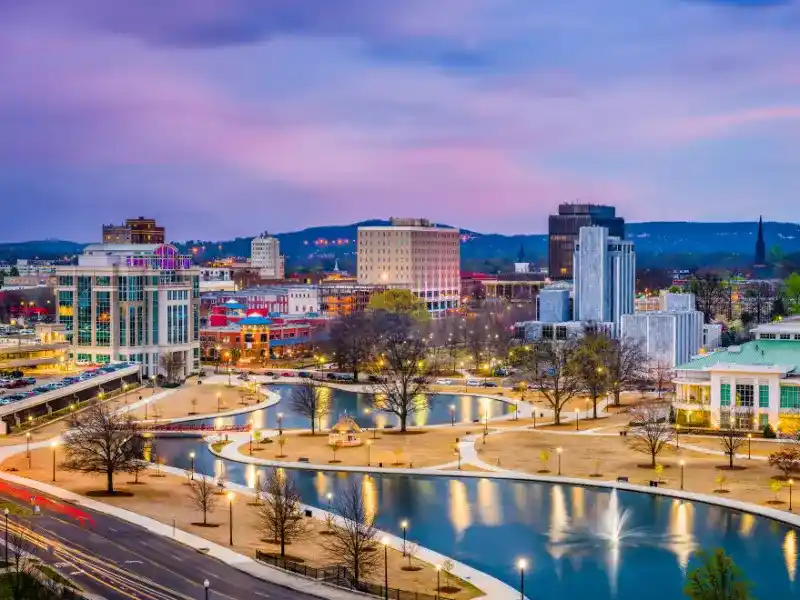 City skyline at dusk with a river, fountains, and illuminated buildings. water damage restoration in Huntsville AL